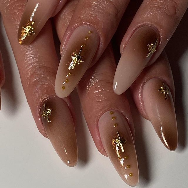 Sophisticated Ombre Nail Design: Nude to Mocha with Glamorous Gold Accents.