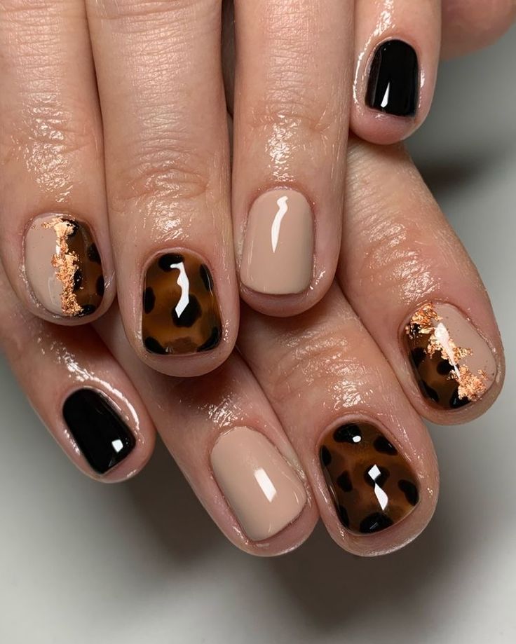 Trendy Nail Design: Glossy Black and Nude with Leopard Print and Sparkling Copper Accents.