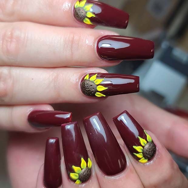 Playful Autumn Nail Design: Deep Maroon Base with Cheerful Sunflower Accents