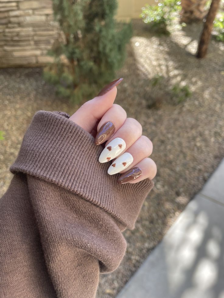 Charming Heart-Accented Nail Design in Deep Brown and Creamy White.