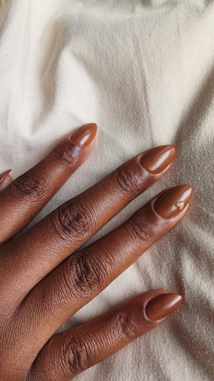 Sophisticated Almond-Shaped Nails with Playful Heart Accent in Warm Brown Polish