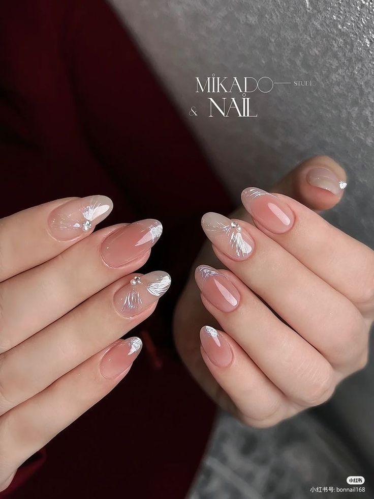 Chic Soft Pink and White Floral Nail Design with Sparkling Gem Accents.