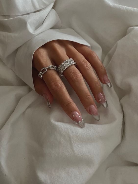 Chic French Manicure: Elegant Nude Base with Striking Silver Tips and Gemstone Embellishments.