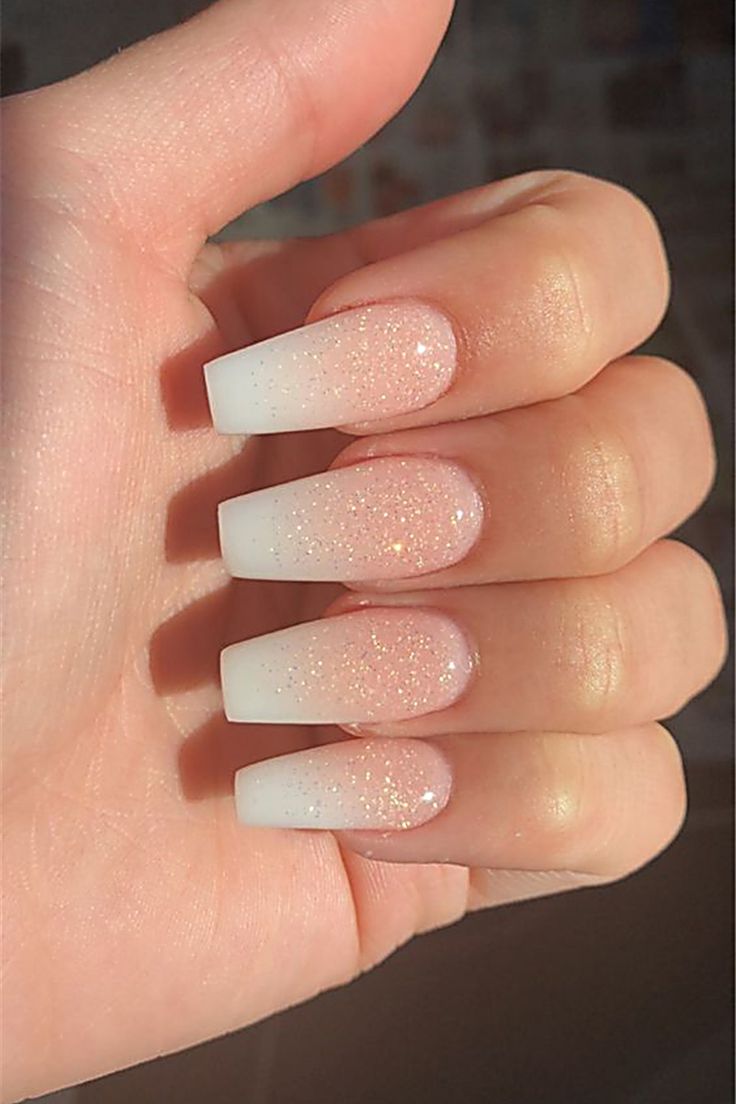 Elegant Ombre Nails: Soft White Tips Transitioning to Sparkling Pink for a Glamorous Look.