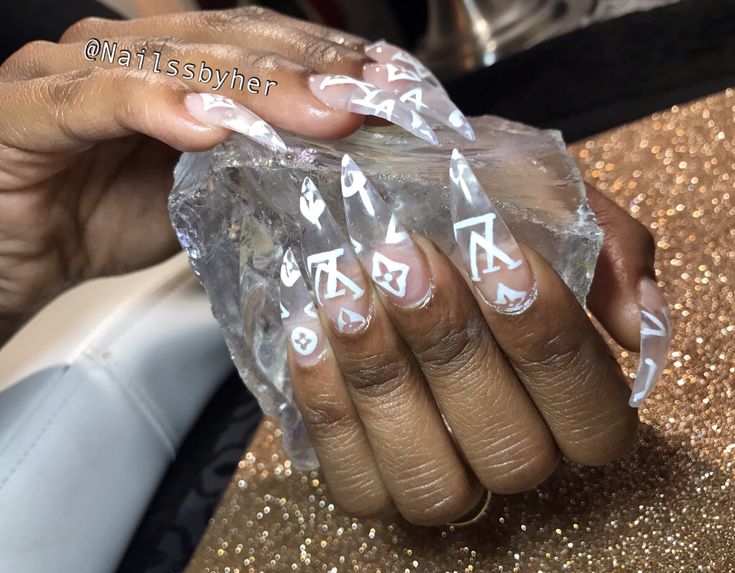 Chic Long Nails: Clear Base with Intricate White Patterns for a Luxurious Statement.