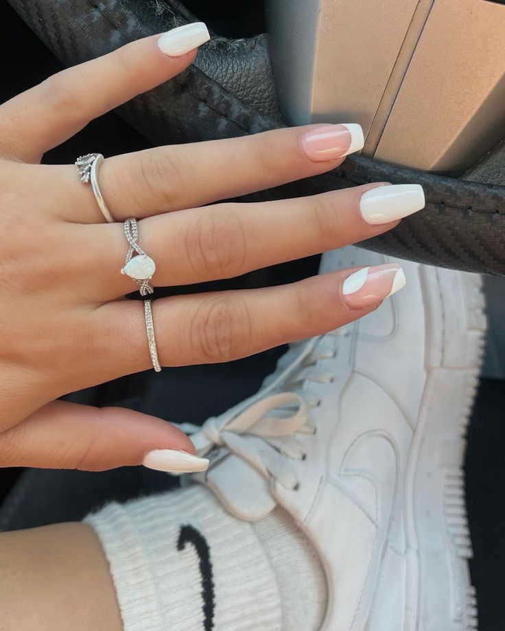 Sophisticated Almond-Shaped White Nails with Chic French Tips Enhance Modern Casual Style.