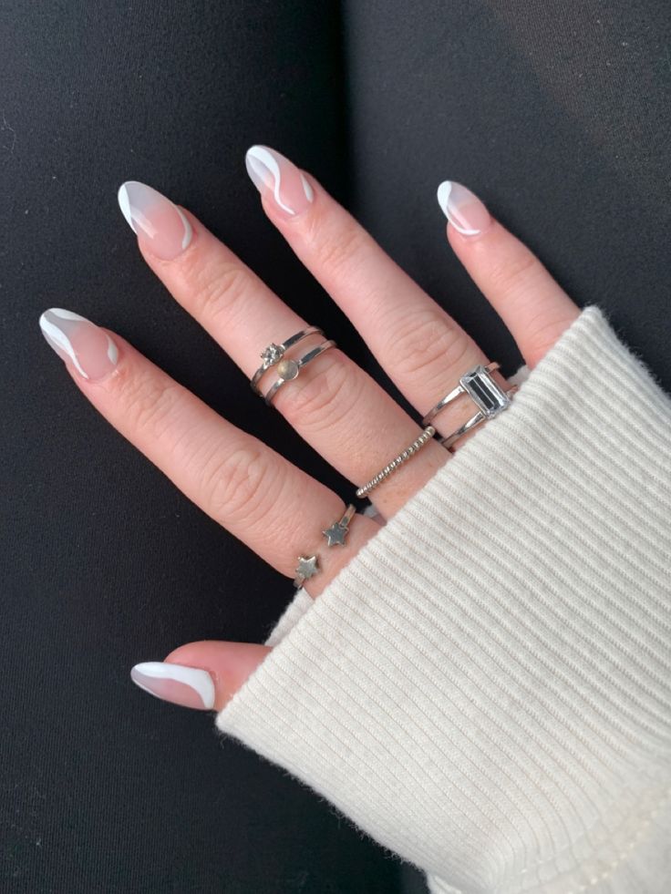 Chic French Tip Nails Complemented by Silver Rings and a Cozy Sweater.