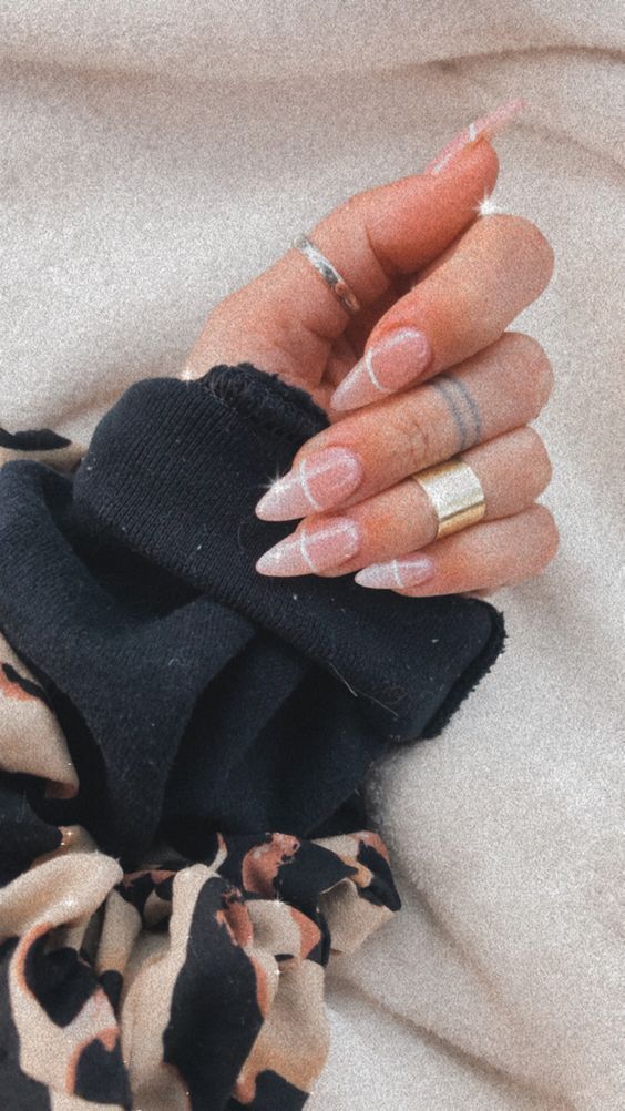 Elegant Almond-Shaped Nail Design with Subtle French Manicure and Minimalist Jewelry.