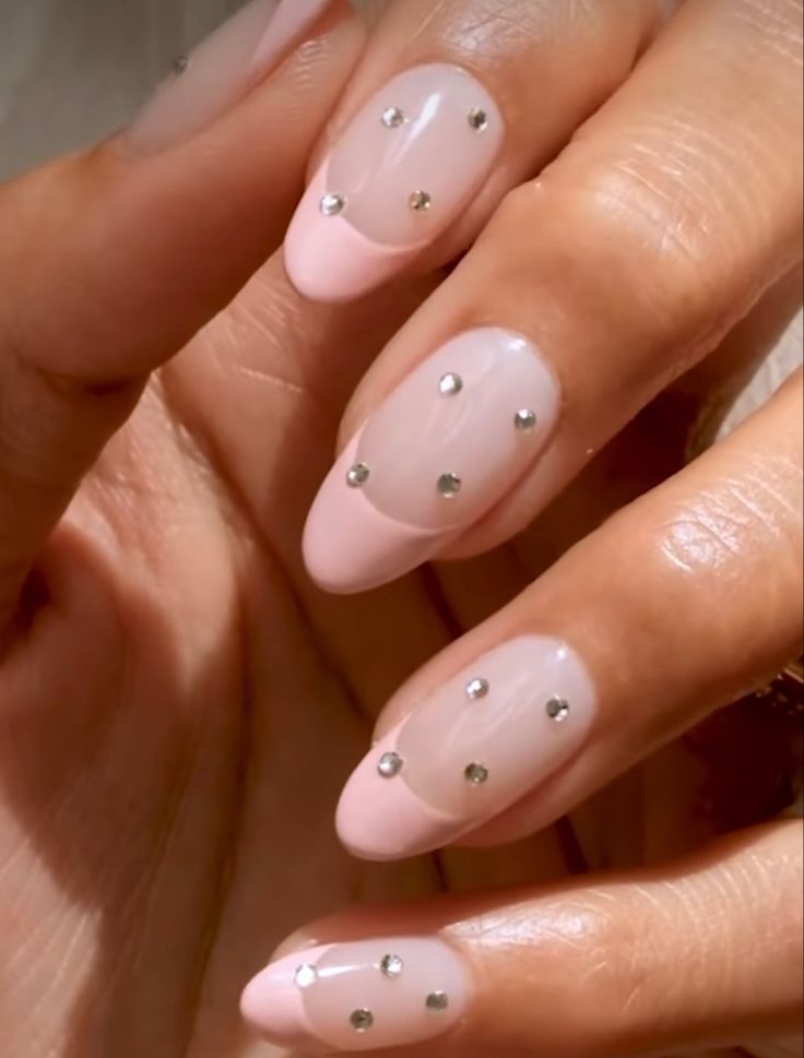 Chic Soft Pink Nail Design with Metallic Studs for a Modern Touch.