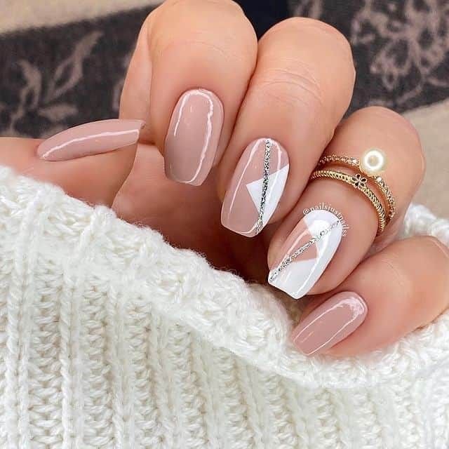 Chic Nude and White Nail Design with Geometric Shapes and Silver Accents.