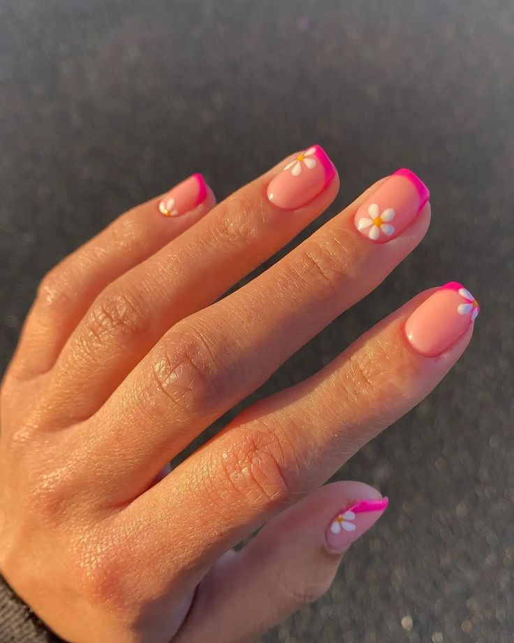 Charming Floral Nail Design: Soft Pink Base with Vibrant Pink Tips and Daisies for a Fresh, Feminine Look.