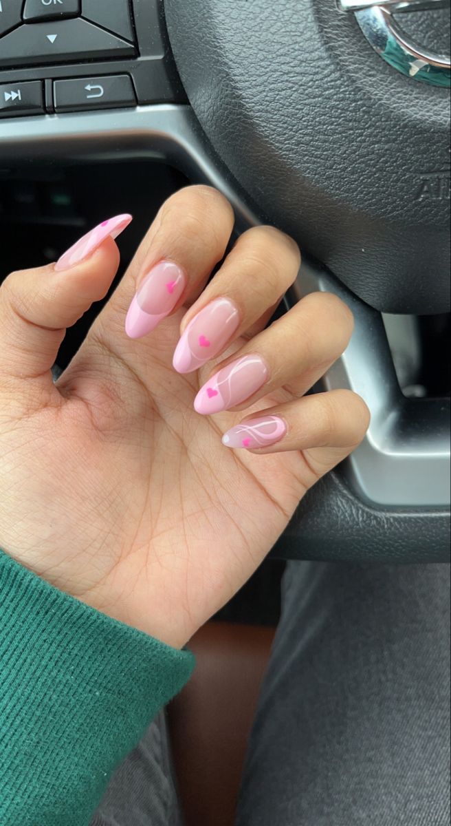 Elegant Pink and Clear Nail Design with Heart Motifs and Delicate Swirls.