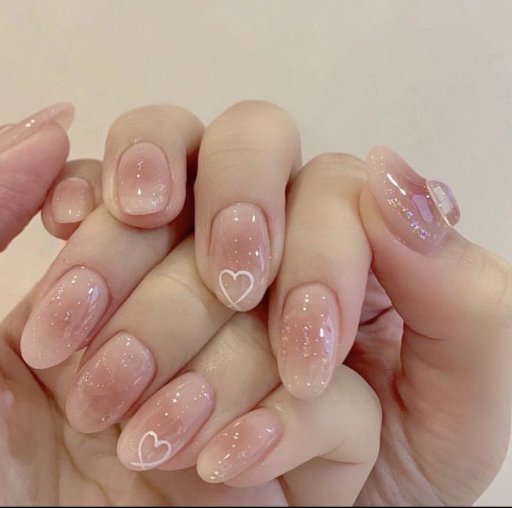 Charming Ombre Nail Design with Heart Accents and Sparkling Finish.