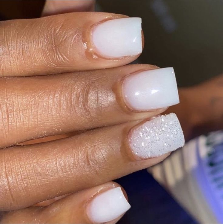 Chic White Manicure with Glossy Textures and Glamorous Glitter Accent.