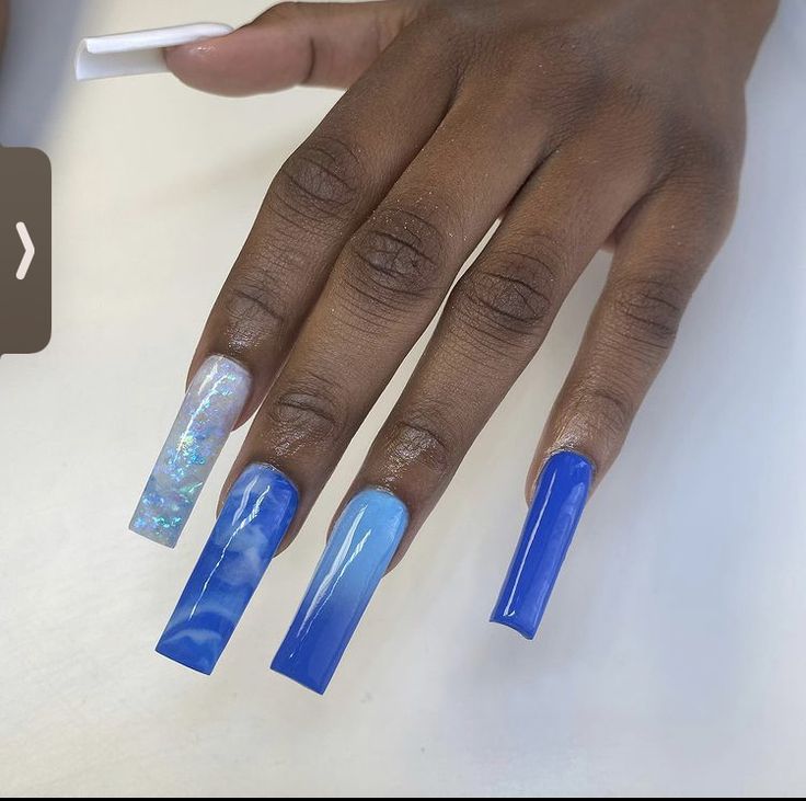 Elegant Ombre Blue Nail Design with Glamorous Accents and Unique Swirl Pattern.