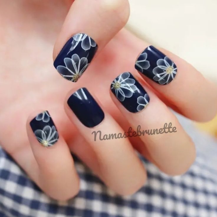 Elegant Navy Blue Nail Design with Delicate White Floral Patterns for a Stylish Touch.