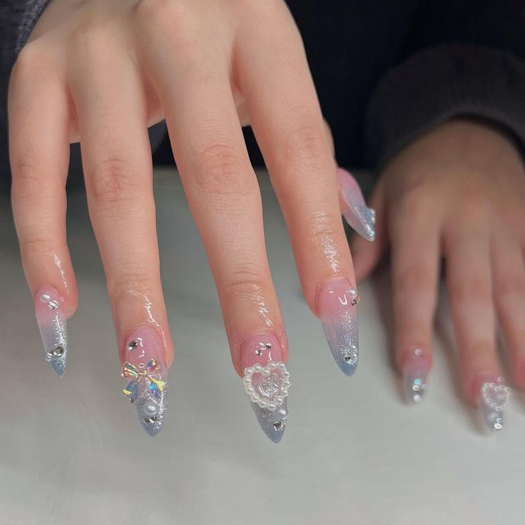 Sophisticated Stiletto Nail Design with Soft Pink, Shimmering Silver, and Glamorous Embellishments.