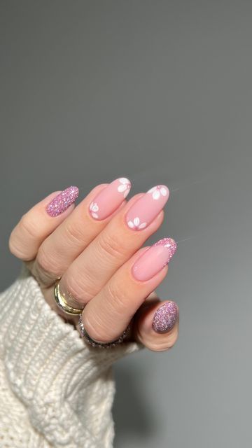 Chic Soft Pink Nail Design with Delicate White Florals and Glitter Tips for Versatile Elegance.