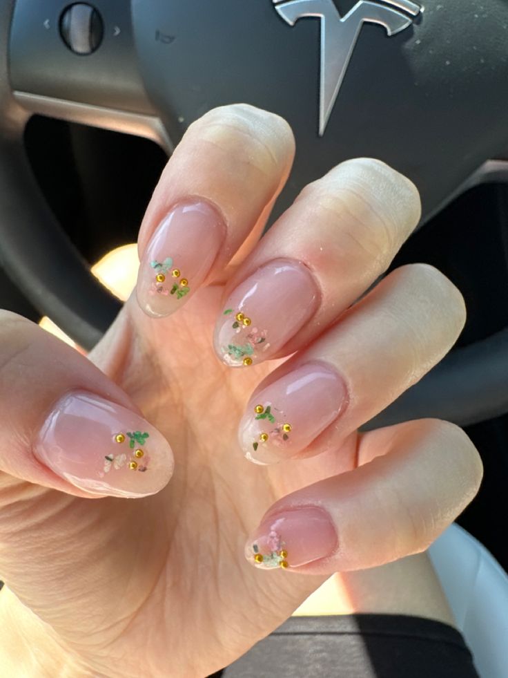 Chic Floral Nail Design: Soft Nude Base with Colorful Flowers and Gold Accents.