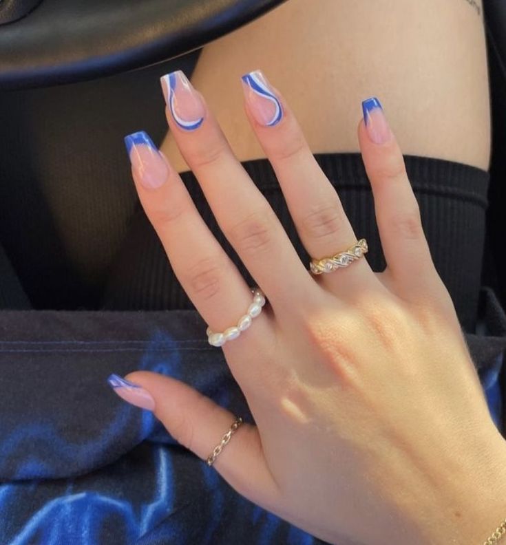 Modern French Tip Nail Design with Pastel Pink and Vibrant Blue Tones, Enhanced by Artistic Swirls and Elegant Rings.