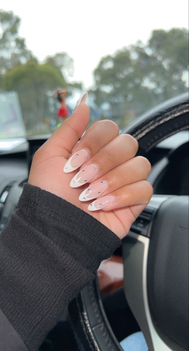 Elegant Almond-Shaped French Manicure with Nude Base, White Tips, and Black Gem Accents.