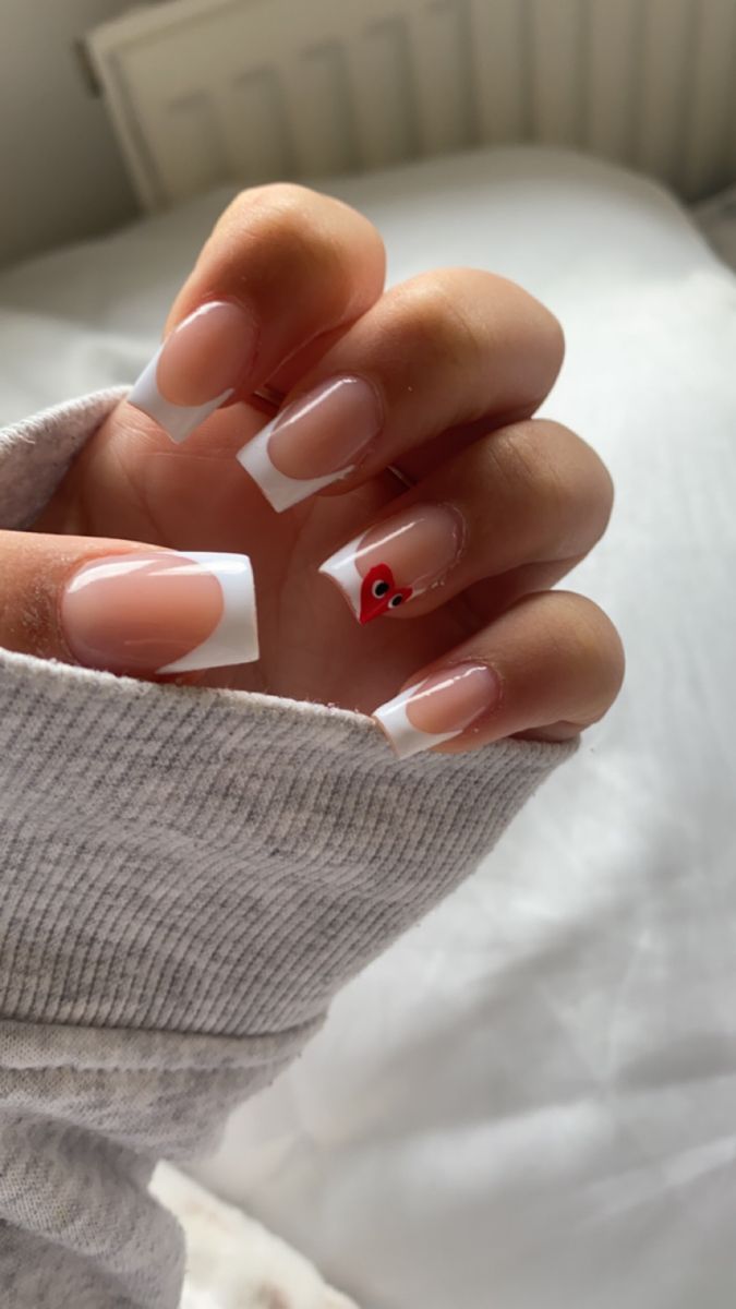 Playful Chic French Manicure with Vibrant Red Accent Nail.