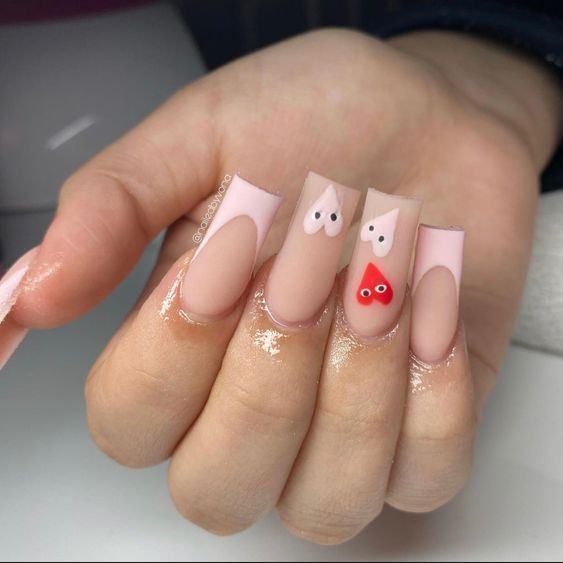 Whimsical Nude and Soft Pink Nail Design with Heart Shapes and Mixed Finishes.