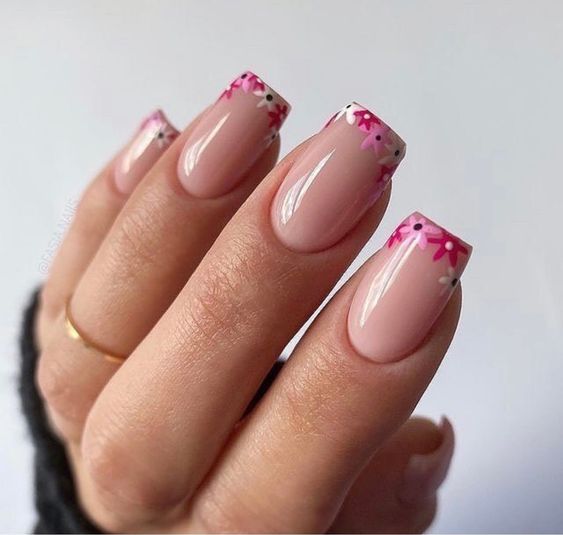 Chic Floral Nail Art with Soft Pink Base and Playful Accents