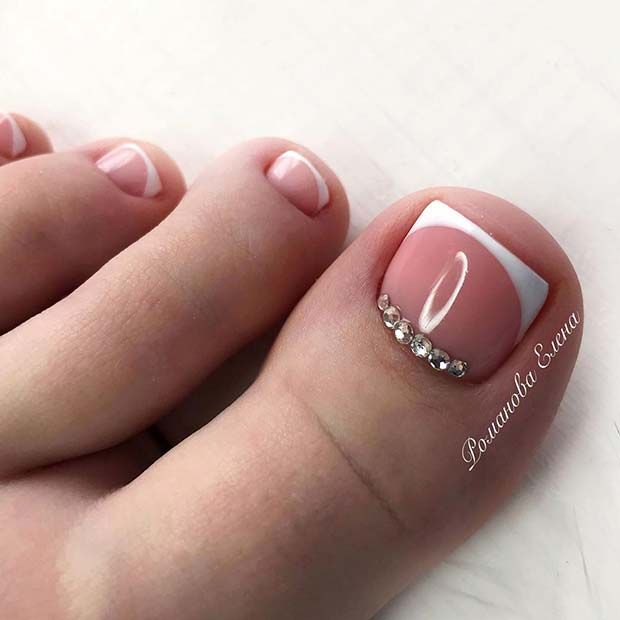 Elegant Soft Pink and White Pedicure with Sparkling Rhinestones for a Glamorous Look.