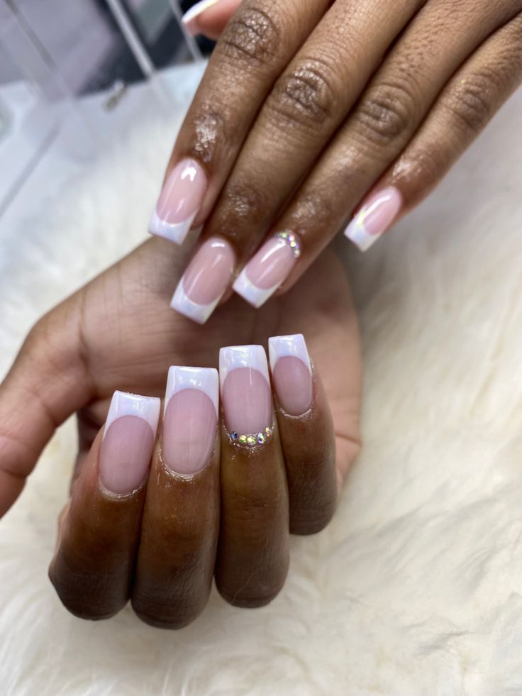 Chic French Manicure with Nude Tips and Rhinestone Accents: A Modern Elegance.