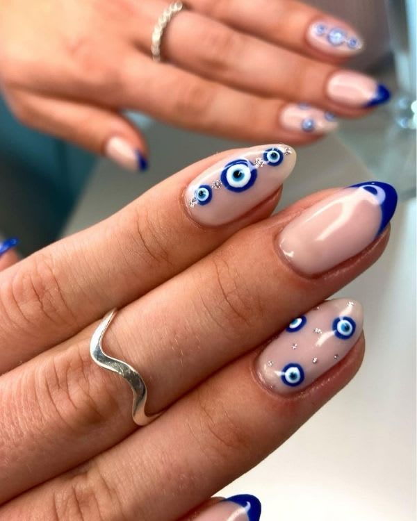 Sophisticated Nail Art: Natural Base Enhanced with Playful Blue Eye Motifs