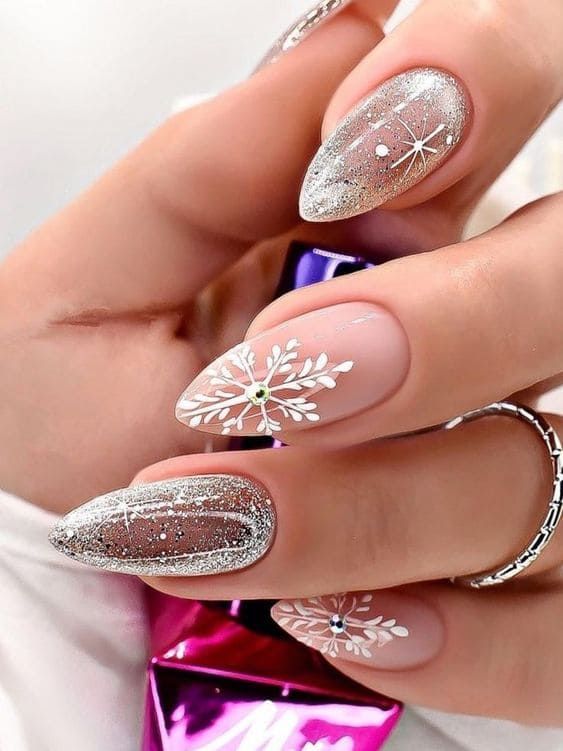 Elegant Glittery Silver and Nude Nail Design with Intricate Floral Patterns and Sparkling Embellishments.