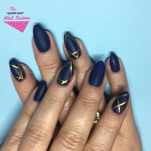 Chic Almond-Shaped Navy Blue Nails with Geometric Gold Lines and Matte Finish.