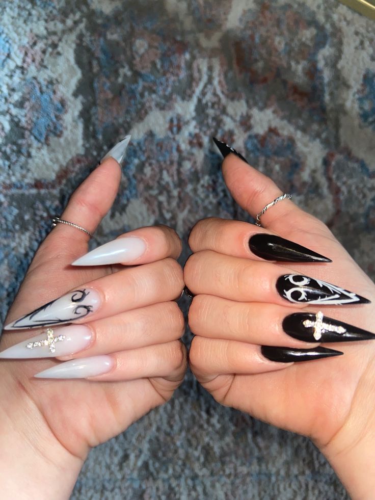 Striking Black and White Stiletto Nails with Intricate Designs and Glamorous Embellishments.