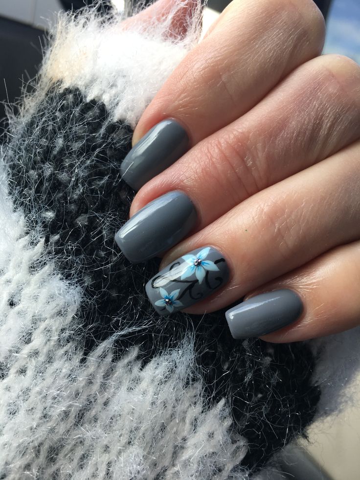 Sophisticated Gray Nail Design with Floral Accents and Blue Embellishments.