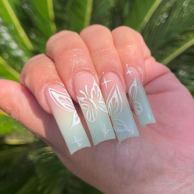 Elegantly Whimsical Ombre Nails with Translucent Green and Delicate Butterfly Motifs.