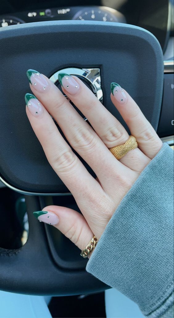 Chic French Tip Nail Design with Vibrant Green Tips and Elegant Embellishments.