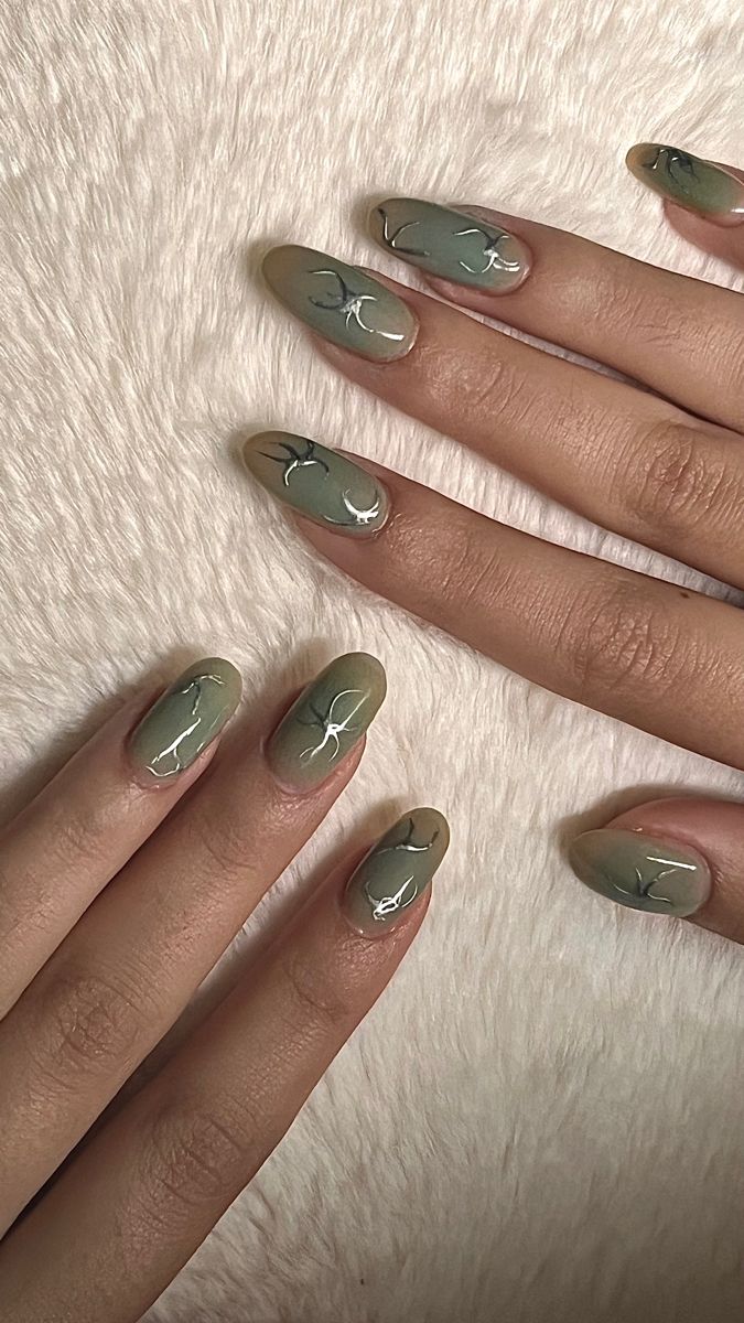 Elegant Earthy Green Nail Design with Abstract Black Lines for a Modern Minimalist Look.