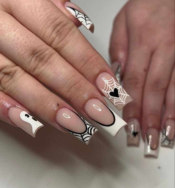 Spooky Elegant Nail Design: Intricate Spider Webs and Ghost Motifs in Soft Nude and Bold Black.