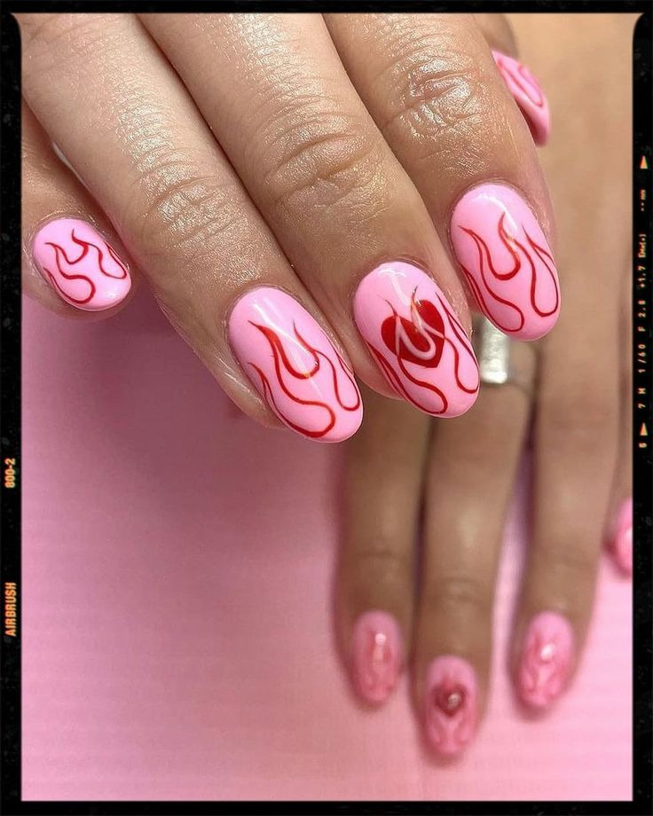 Vibrant Pink Flame-Inspired Nail Design with Heart Accents for a Bold Statement Look.