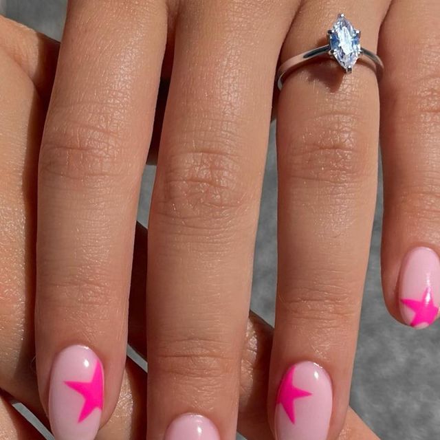 Chic Playful Pink Nails with Star Designs and Elegant Accessories.