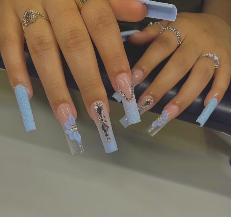 Elegant Pastel Blue Square-Tipped Nail Design with Unique Embellishments.