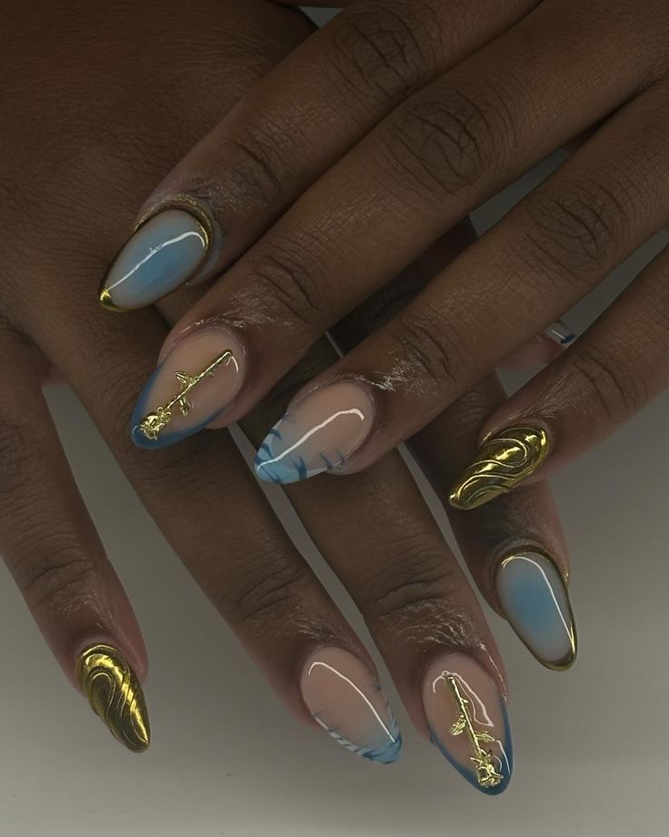 Chic Nail Design: Soft Blue and Nude with Glamorous Gold Accents and Trendy Marbling