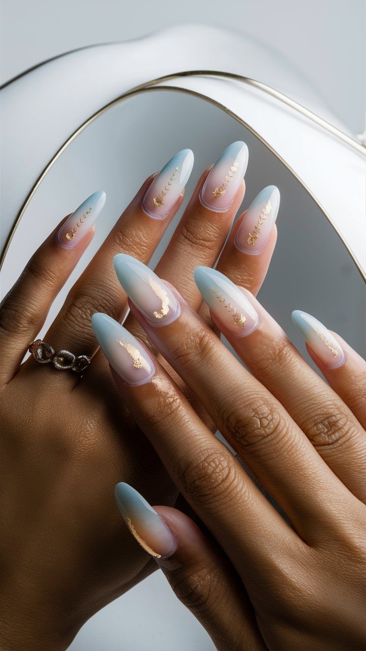 Chic Ombre Nails: A Elegant Blue-Pink Gradient with Sophisticated Gold Accents in Almond Shape.