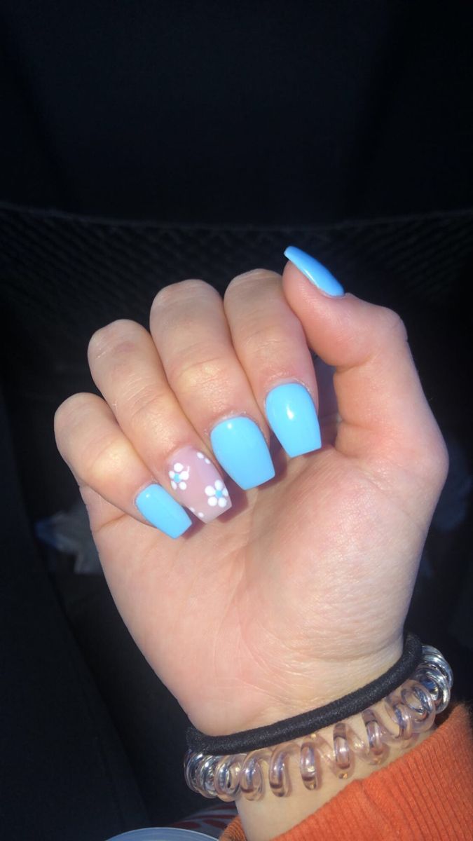 Vibrant Blue Nail Design with Playful Floral Accents for a Fresh, Cheerful Look.