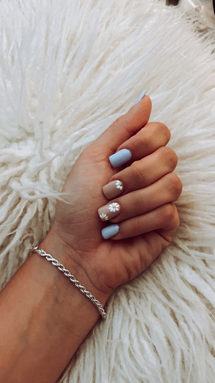 Whimsical Soft Blue and Sandy Nude Nail Design with Floral Accents