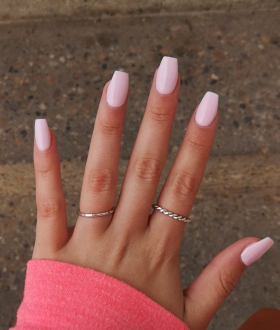 Elegant Pastel Pink Nails with Square Tips and Minimalist Silver Rings for a Chic Look.