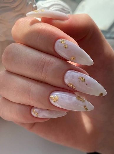 Sophisticated Pearlescent Stiletto Nails with Glamorous Gold Leaf Accents.