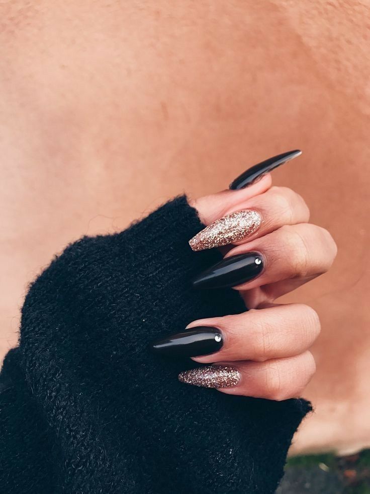 Elegant Stiletto Nail Design: Matte Black with Glittering Gold Accents