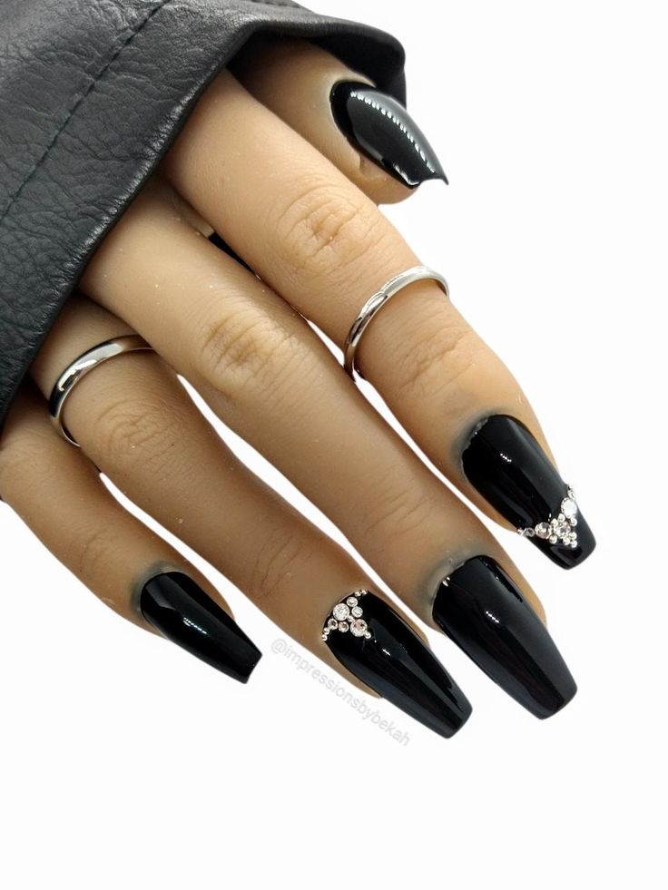 Sophisticated Black Nail Design with Rhinestones and Silver Accents.